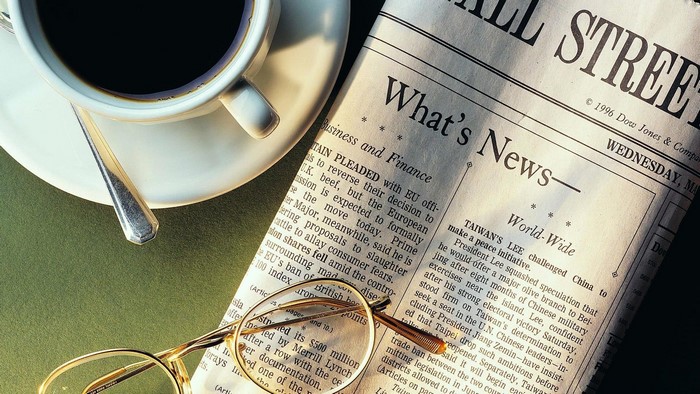 Wall Street Journal newspaper with coffee and glasses