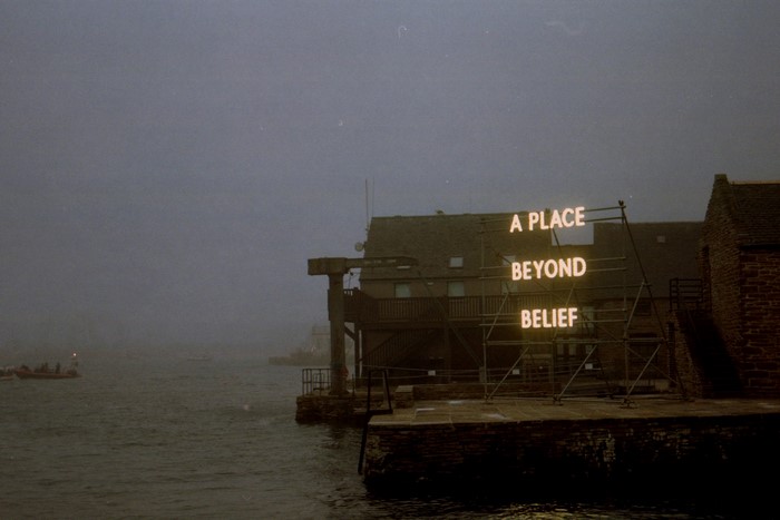 Neon sign on a building by the water