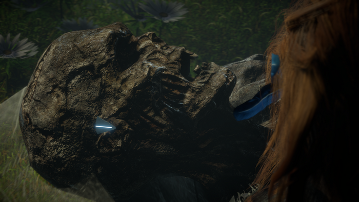 Aloy from Horizon Zero Dawn examines a stone head