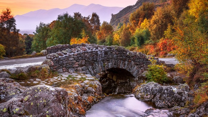 Ashness Bridge over stream in autumn with mountains