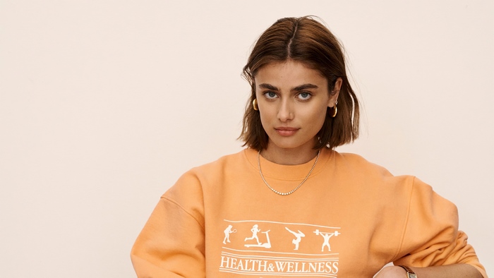 Taylor Marie Hill wearing an orange sweatshirt