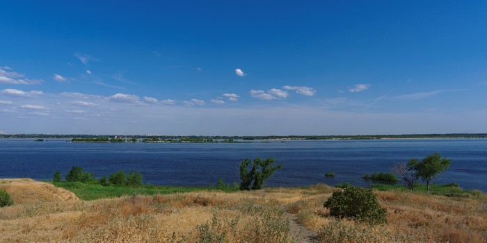 Wide river under a blue sky with clouds