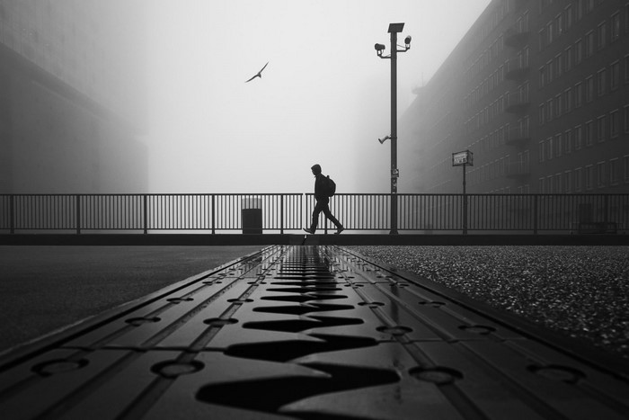 Man walking on a bridge in Hamburg during foggy weather
