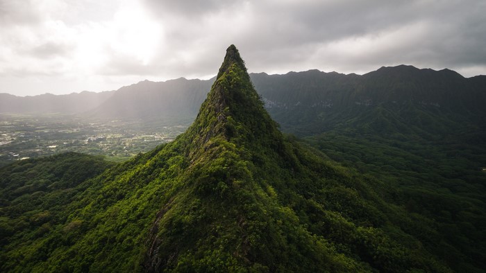 Jagged green mountain peak overlooking a valley in Hawaii