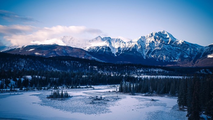 Snowy mountains and frozen river in Alberta, Canada