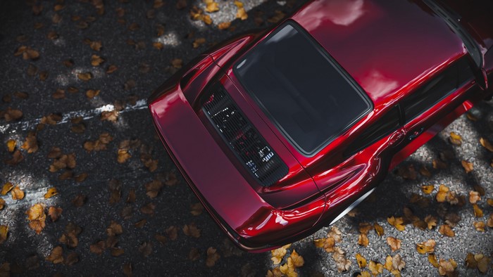 Red Porsche 959 on asphalt with fallen leaves