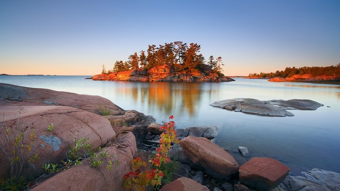 Island with trees at sunrise over water in Ontario, Canada