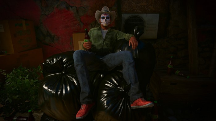 Man in Day of the Dead mask sitting on trash bags