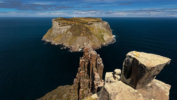 Island with lighthouse and rock formations in the sea