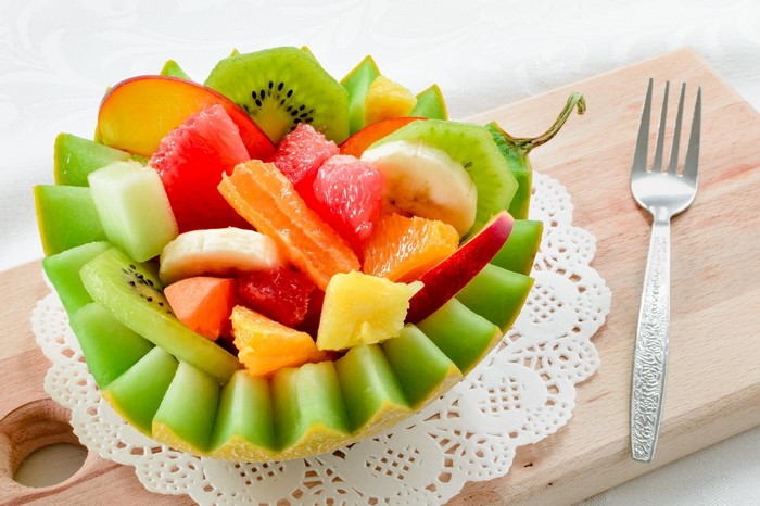 Fruit salad in a melon bowl with a fork