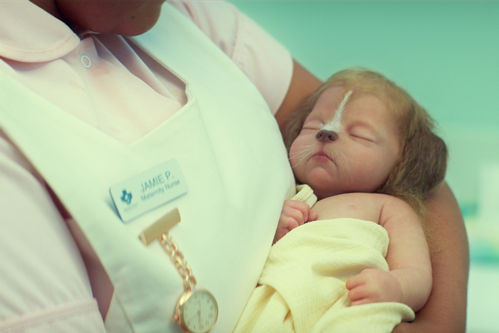 Baby with dog features held by a nurse