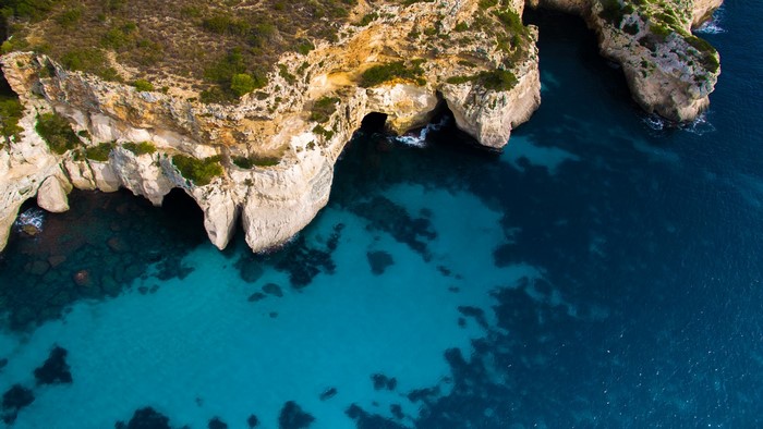 Aerial view of limestone cliffs and clear turquoise water