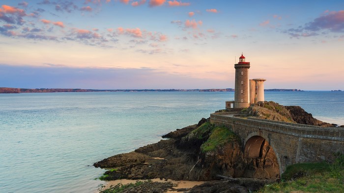 Lighthouse on a rocky island with a bridge in Brittany, France