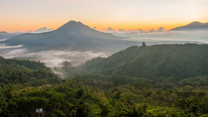 Misty sunrise over mountains and forest in Bali, Indonesia