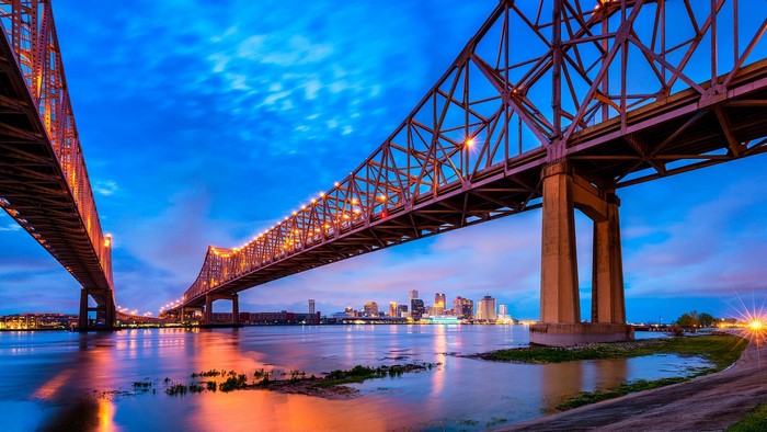 New Orleans cityscape and bridges over Mississippi River at dusk