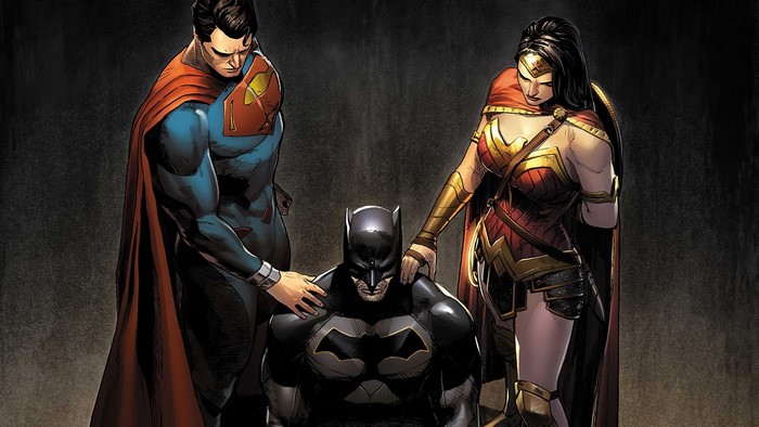 Superman and Wonder Woman place hands on Batman