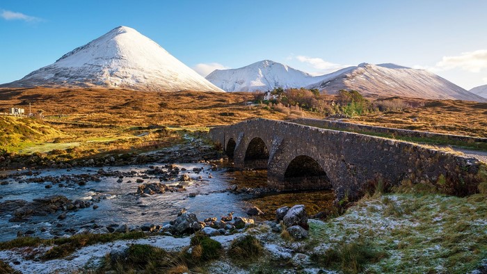 Stone bridge over a river with snowy mountains in Scotland