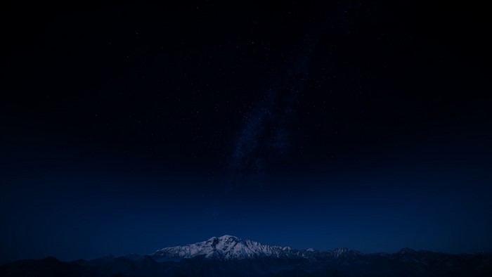 Snow-capped mountains under a starry night sky