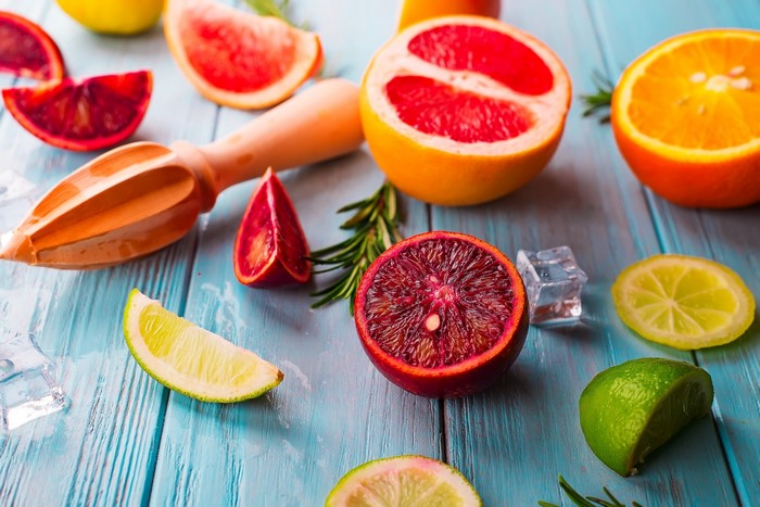 Citrus fruits and juicer on a blue wooden table