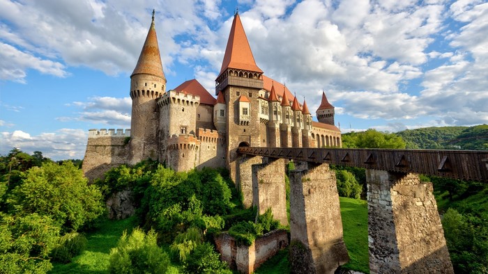 Corvin Castle with wooden bridge and green trees