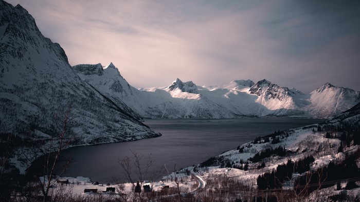 Snowy mountains and a dark body of water