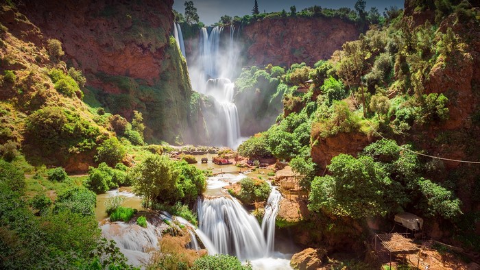 Cascading waterfalls in a rocky, green gorge in Morocco
