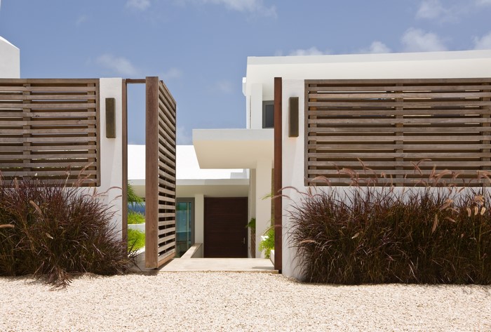Modern house with wooden fence and gravel yard