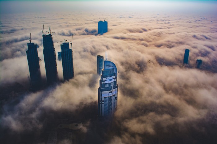 Futuristic city skyscrapers emerging from clouds