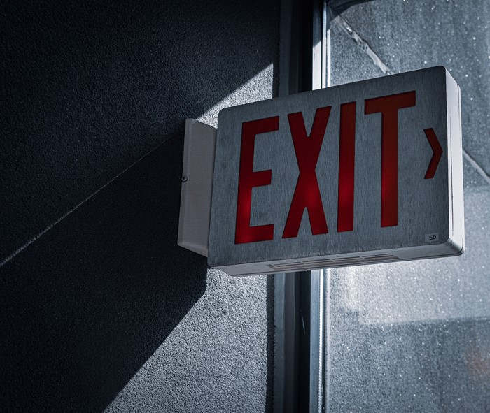 Red illuminated EXIT sign on a dark wall