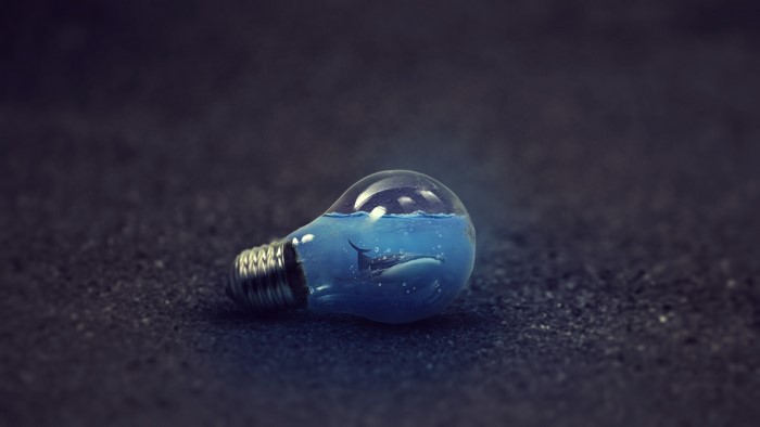 Whale swimming inside a lightbulb filled with water
