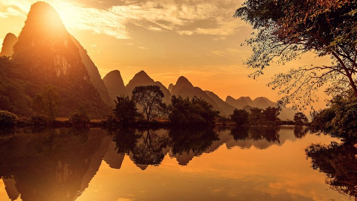 Karst mountains reflected in a lake at sunset