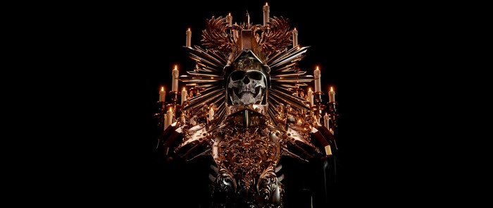 Skull in ornate golden armor with candles