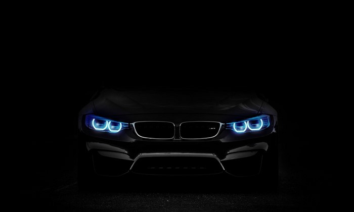 Black BMW M4 with blue headlights