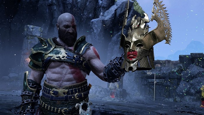 Kratos from God of War holding a golden mask