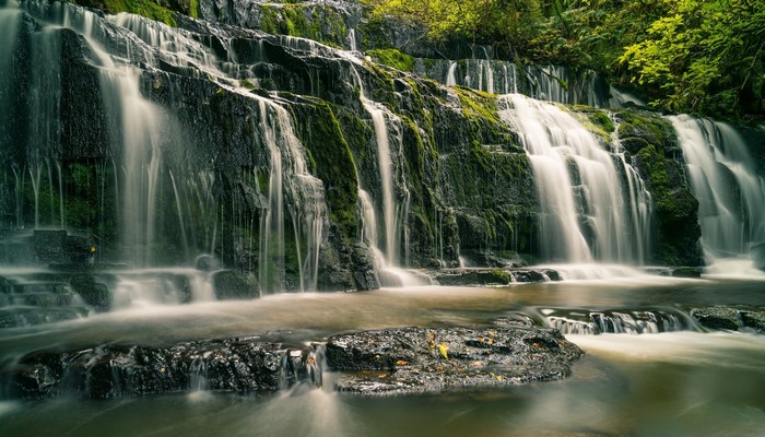 Waterfall cascading over moss-covered rocks in a forest