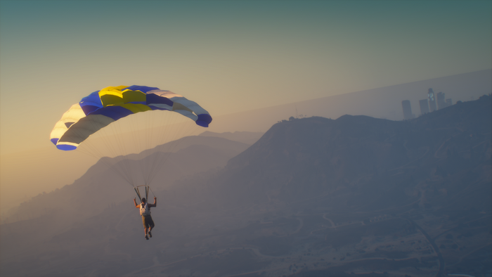 Skydiver over mountains with city skyline in Grand Theft Auto V