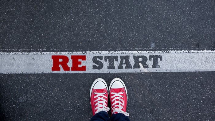 Red shoes standing at the restart line on asphalt
