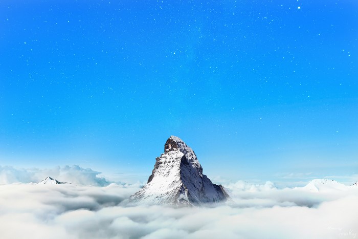 4K mountain peak above clouds under starry sky