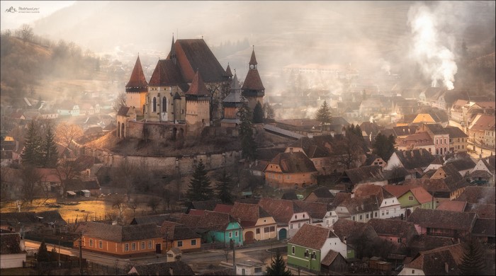 Castle and village in mist with smoke