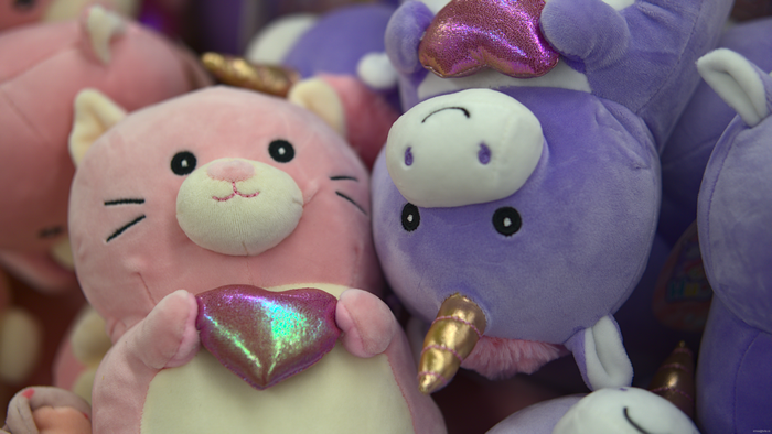 Pink cat and purple unicorn plush toys
