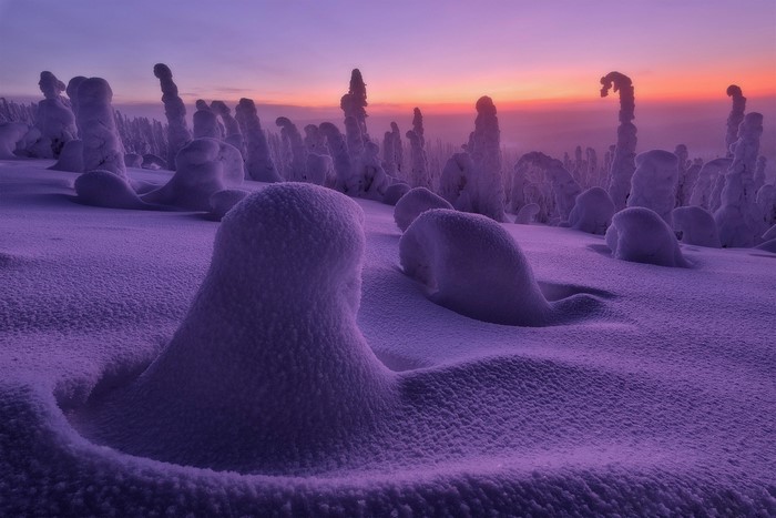 Snow-covered landscape with strange formations at sunset