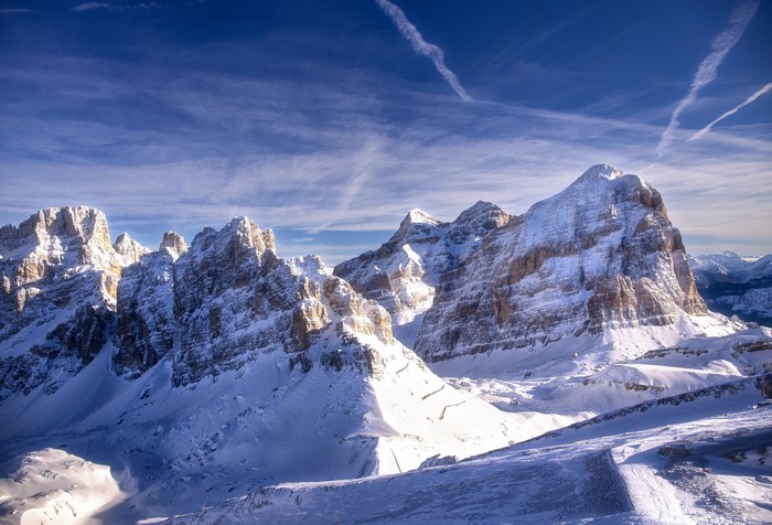 Snow-covered Dolomites mountains in Italy with chemtrails