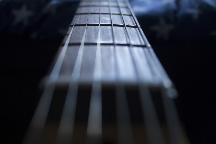 Close-up of a guitar fretboard with bokeh background