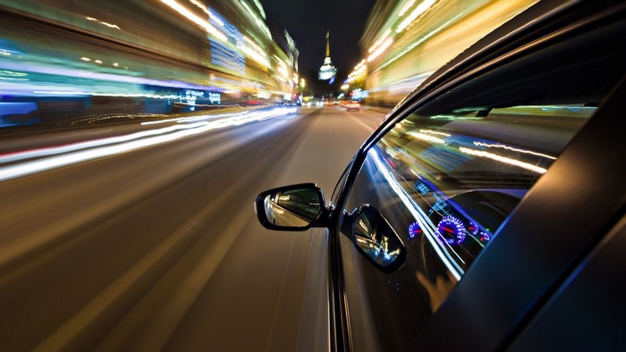 Car driving through a city at night with motion blur