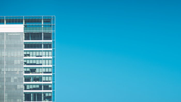 Modern glass building against a clear blue sky