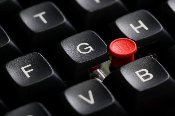 Close-up of a mechanical keyboard with a red button