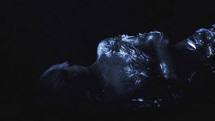 Woman covered in glowing material in Resident Evil 7