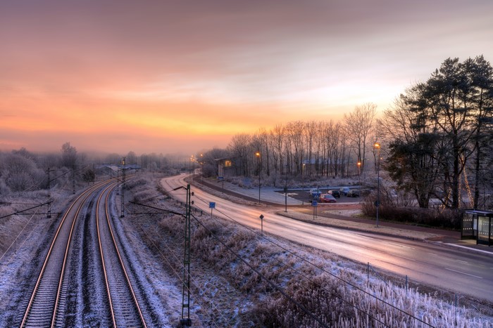 Winter sunset over railroad tracks and road