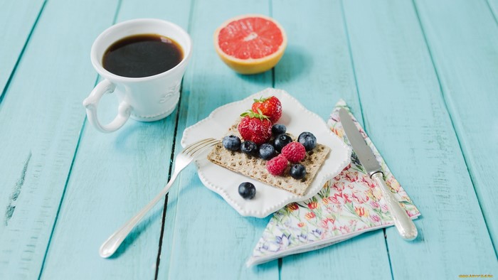 Coffee cup and berries on crackers with grapefruit