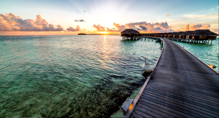 Overwater bungalows and pier at sunset